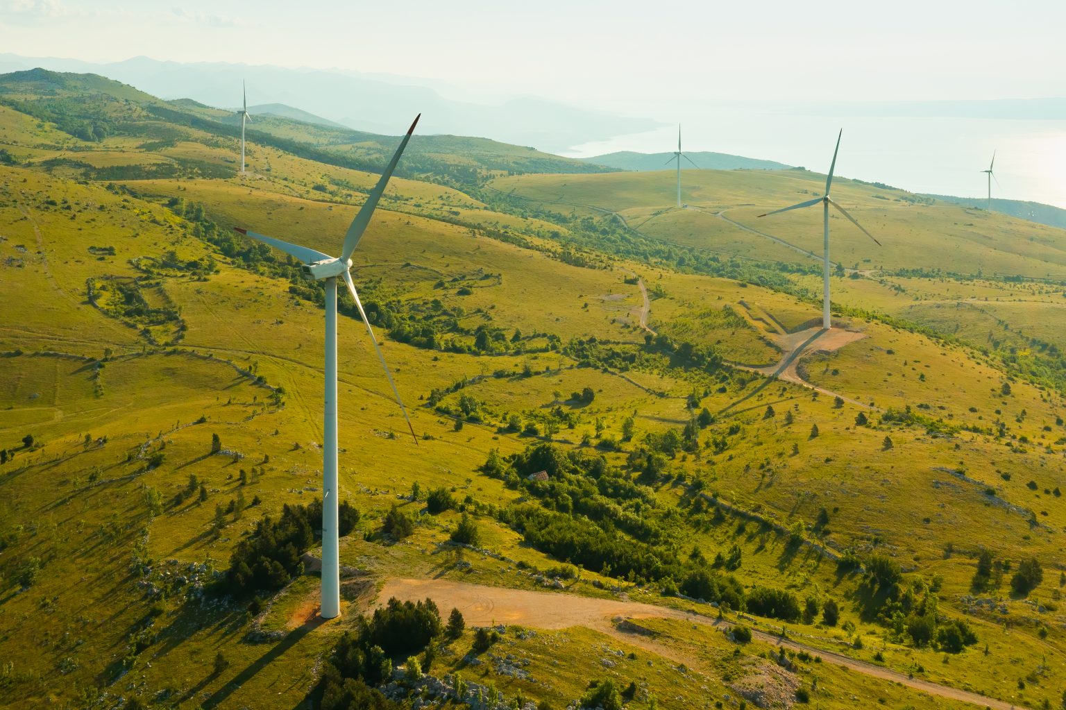 Windmills operate producing green energy on hill slopes